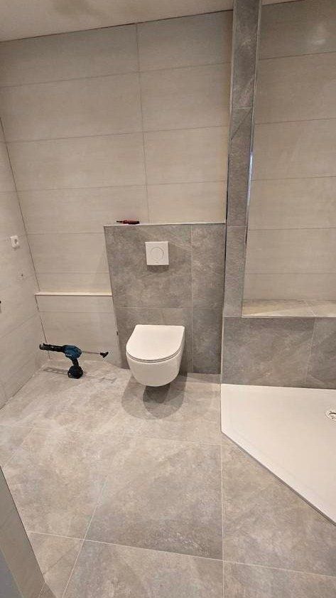 Net geplaatst hangend toilet in grote grijze tegels