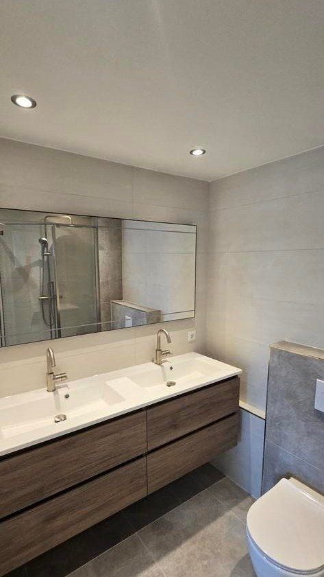 Dubbel badmeubel met houtlook lades en een brede spiegel