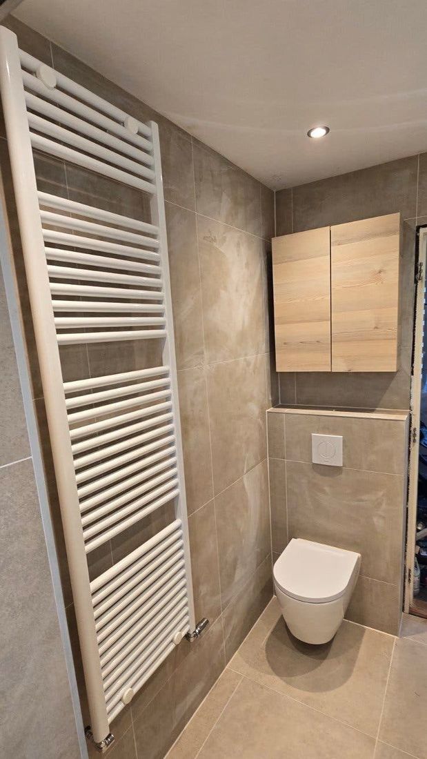 Hangend toilet naast een grote witte handdoekradiator